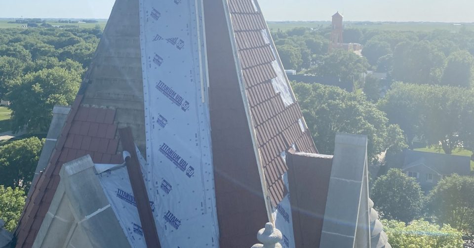 church steeple in the middle of new roofing shingles replacement